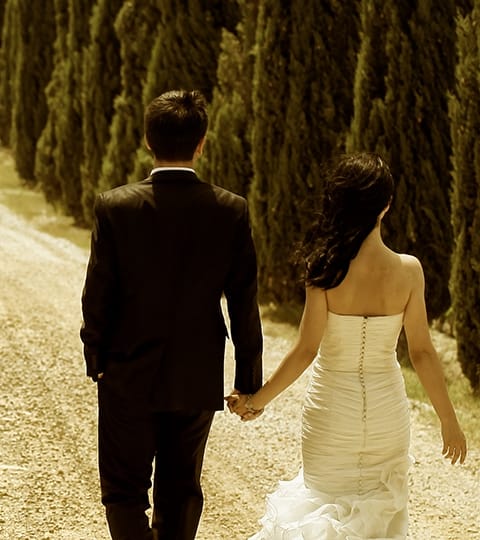 Bride and groom walking down a path.