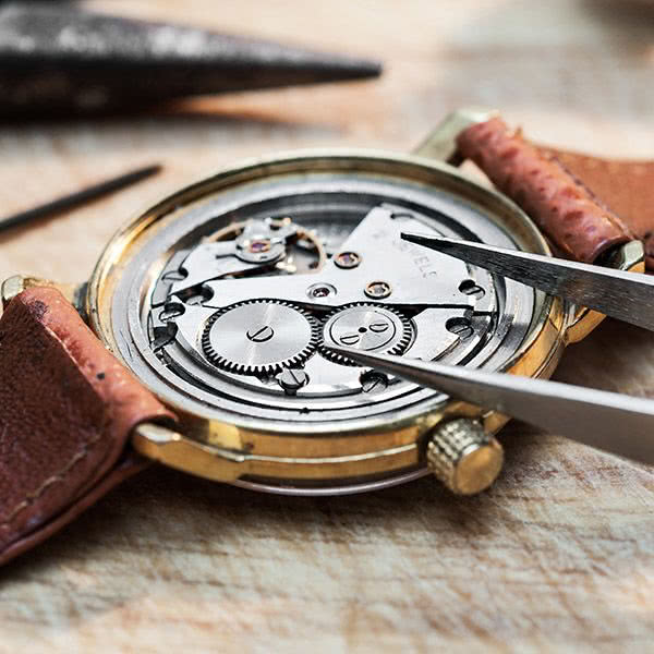 Jeweler repairing watch movement